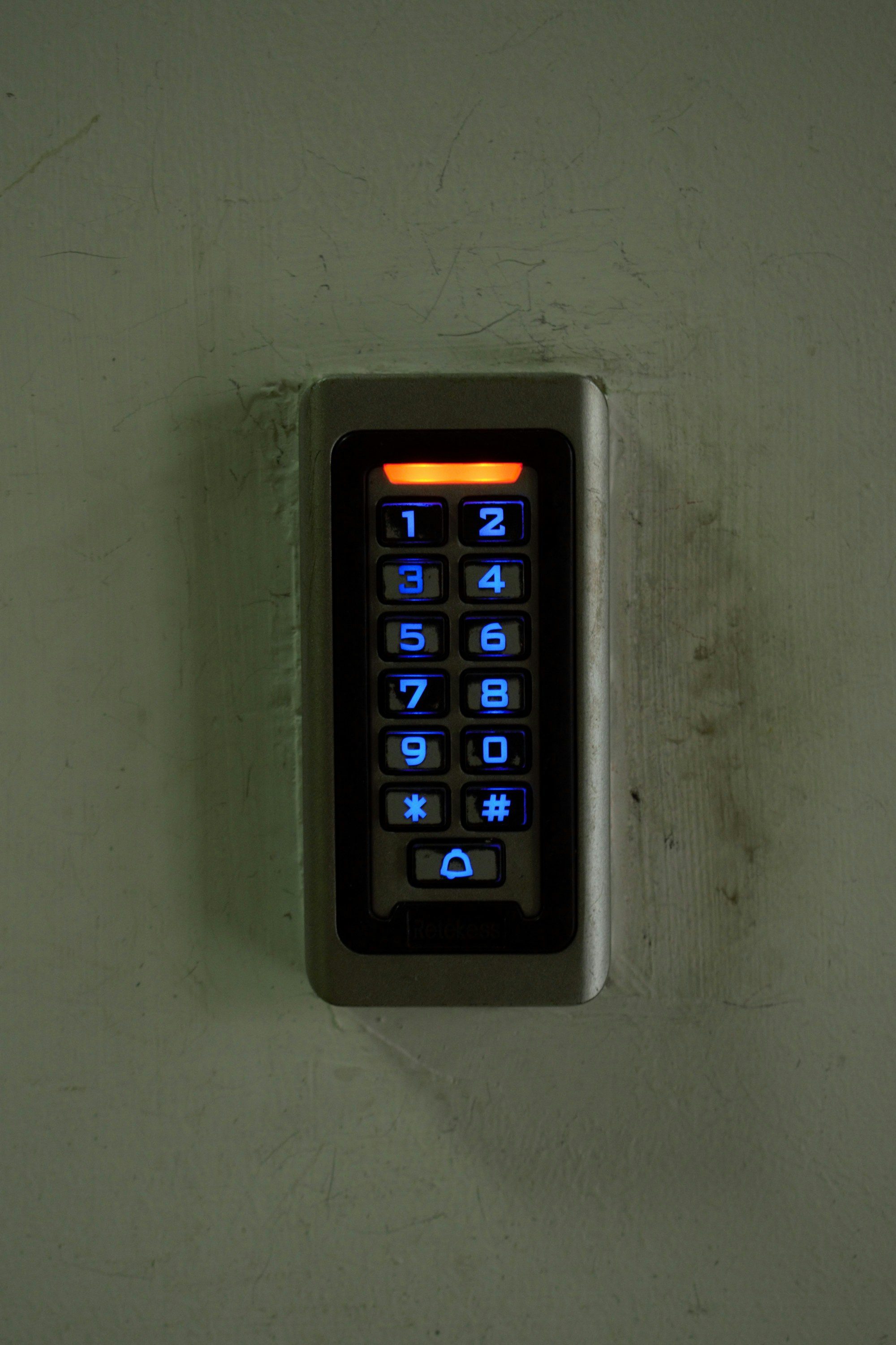 A backlit keypad mounted on a wall