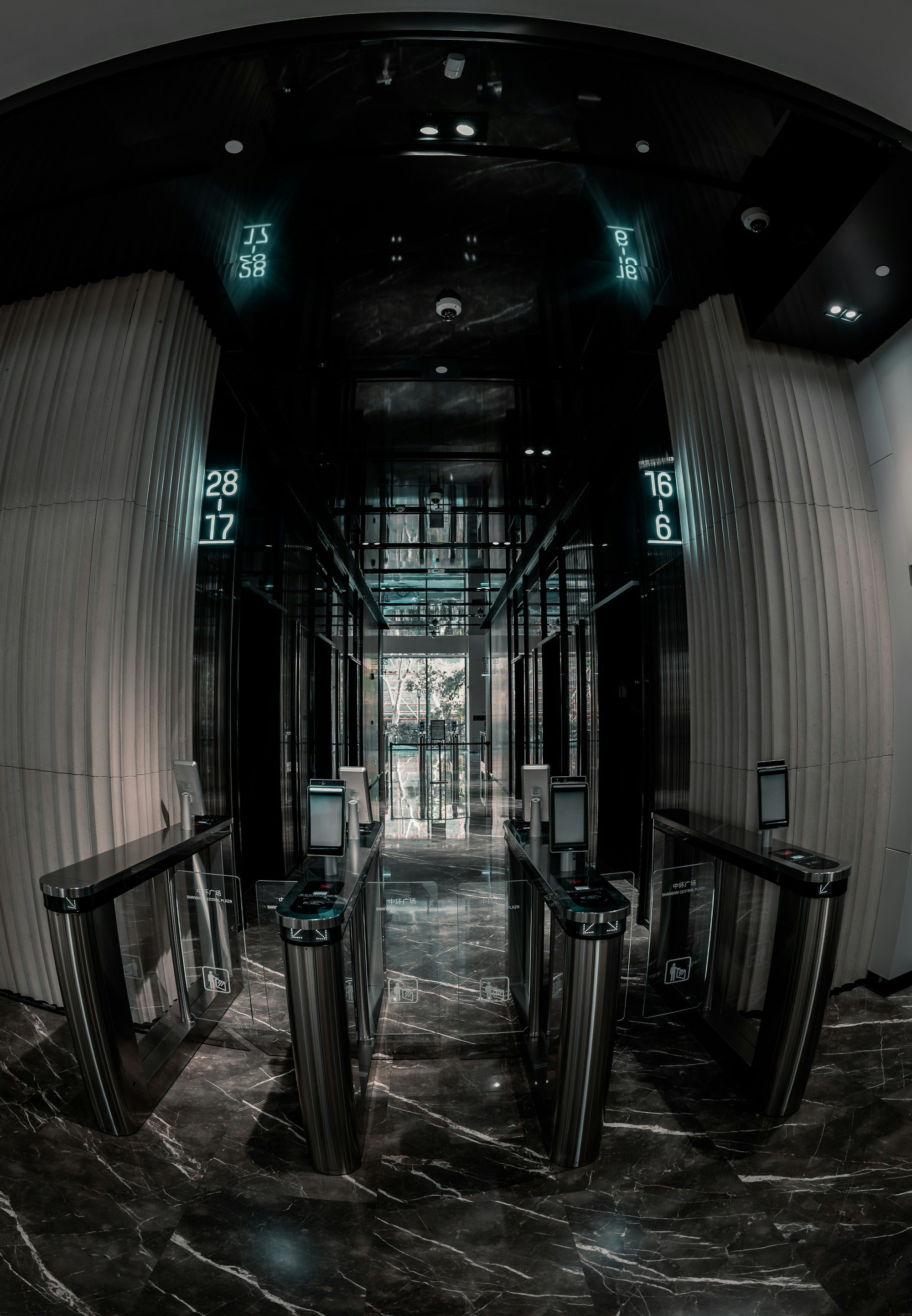 Security turnstiles at a dark, modern building entrance